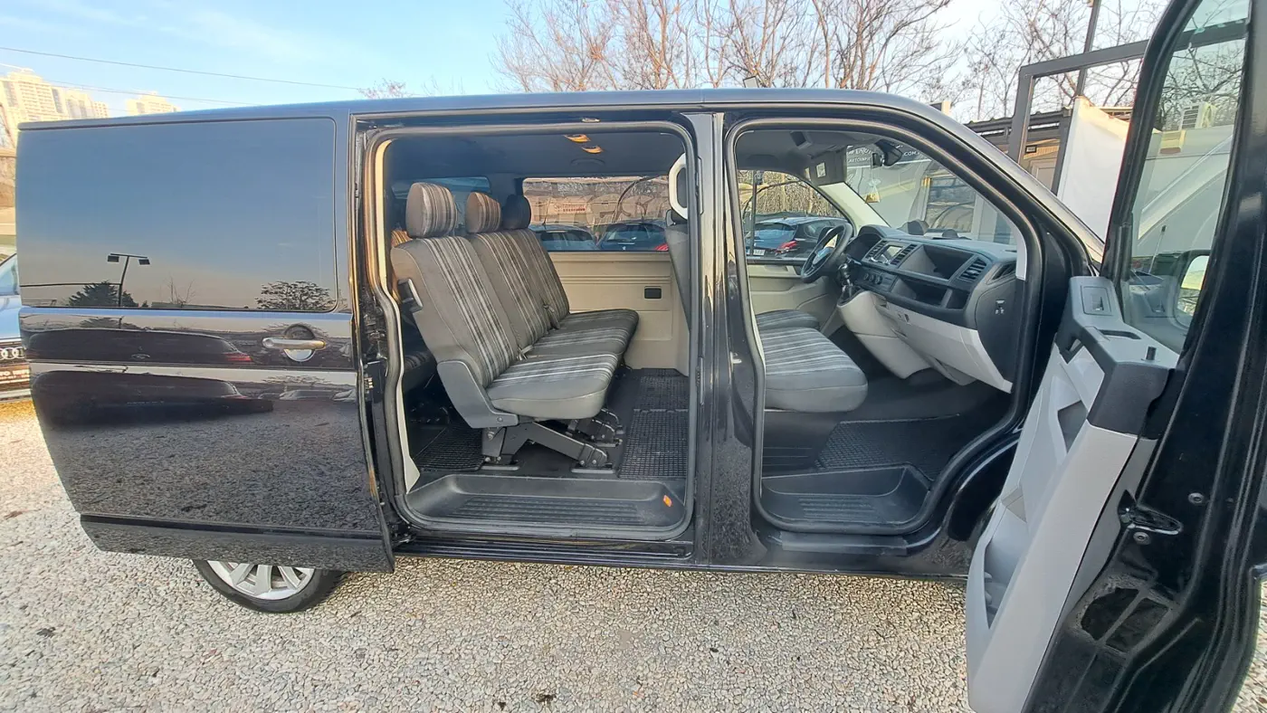 Volkswagen Caravelle with the sliding door and front passenger door open, showing the seats inside